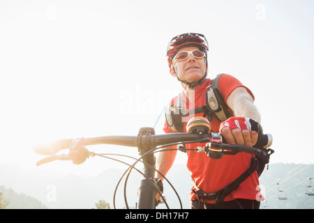 Uomo caucasico spingendo in mountain bike Foto Stock