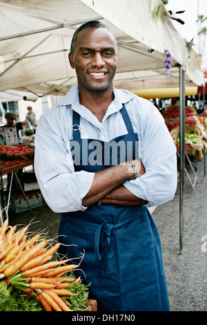 Uomo nero lavora al mercato all'aperto Foto Stock