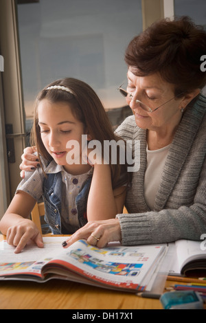 I vecchi donna ispanica di lettura con la nipote Foto Stock