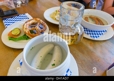 Impostazione tabella nel ristorante bavarese - tipico piatto bavarese con weisswurst, wieners, pretzel e boccale di birra Foto Stock