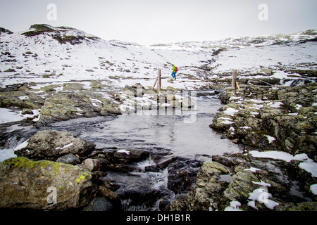 Velocità uomo escursioni nel paesaggio incappucciate di neve, fiume in primo piano, Norvegia, Europa Foto Stock