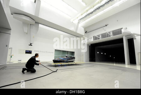 Monaco di Baviera, Germania. 29 ott 2013. Un dipendente detiene una lancia di nebbia mentre Francesco Friedrich anteriore (L) e Alexander Mann sedersi al FES-208 due uomini di Bob in una galleria del vento a l'aerodinamica di centro di ricerca per il produttore di automobili BMW a Monaco di Baviera, Germania, il 29 ottobre 2013. Foto: TOBIAS HASE/dpa/Alamy Live News Foto Stock