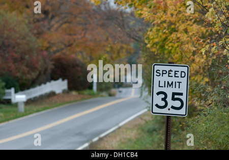 A 35 mph segnale di limite di velocità lungo una suburban New England road in autunno. Foto Stock