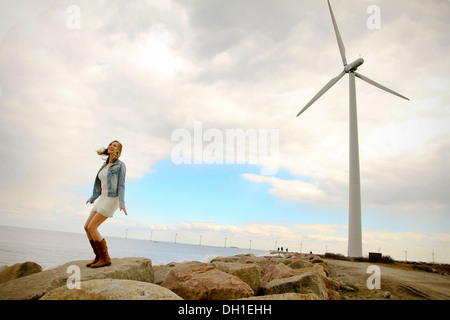 Giovane donna sul lungomare, la turbina eolica in background, Danimarca, Europa Foto Stock