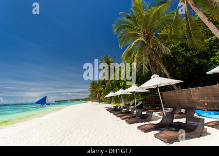 Ombrelloni e sdraio in spiaggia sulla costa tropicale, Filippine, Boracay Foto Stock