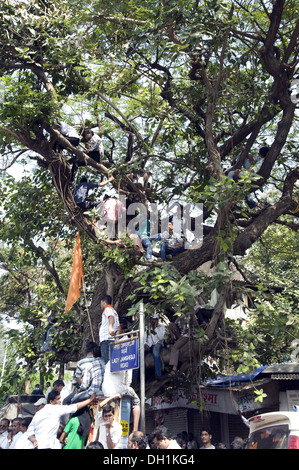 La gente seduta sulla struttura ad albero per vedere il corteo funebre di Shiv Sena Chief Balasaheb Thackeray mumbai maharashtra india asia Foto Stock