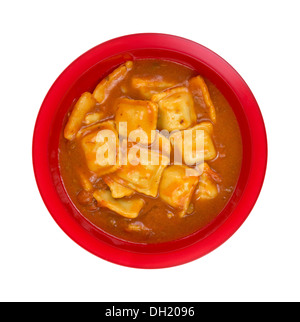 Vista dall'alto di una porzione di ravioli in salsa di pomodoro su uno sfondo bianco. Foto Stock