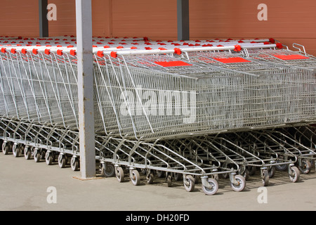 Un sacco di carrelli in metallo su ruote per lo shopping, cibo, stand in fila vicino al negozio Foto Stock