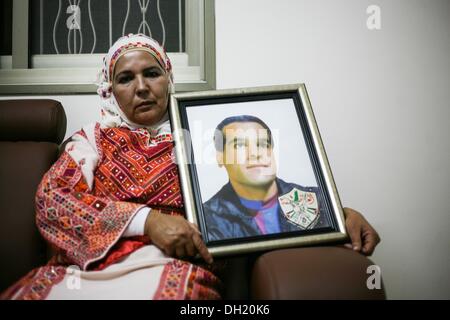 Ramallah, West Bank, Territorio palestinese. 29 ott 2013. Adla Kraja, sorella del prigioniero palestinese Rafa Karaja 51 anni tiene il suo fratello immagine nella città di Ramallah, israeliani Cisgiordania occupata, il 29 ottobre 2013, prima del suo rilascio da 24 anni in una prigione israeliana. Israele è stata la preparazione a rilascio 26 a lungo che serve prigionieri palestinesi, il secondo lotto di 104 detenuti che sono per essere liberato in linea con gli impegni da noi-mediate i colloqui di pace.Foto: Hamde Abu Rahma/NurPhoto Credito: ZUMA Press, Inc./Alamy Live News Foto Stock