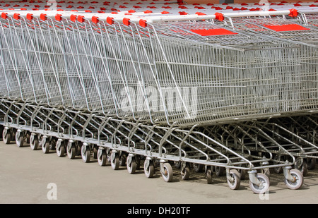 Un sacco di carrelli in metallo su ruote per lo shopping, cibo, stand in fila vicino al negozio Foto Stock