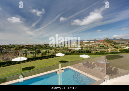 Vista di ombrelloni bianchi sul prato accanto alla piscina della villa di recente costruzione nel sud della Spagna Foto Stock