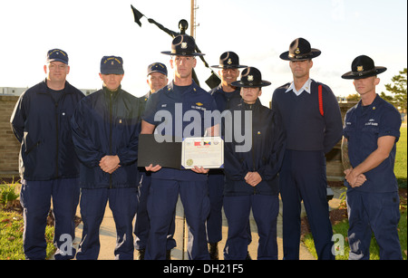 Petty Officer 1. Classe Rick Bauz, vincitore del 2013 della Guardia Costiera concorso di cadenza, pone con i membri del personale del Centro di formazione di Cape May durante una cerimonia di premiazione ott. 24, 2013. Bauz ha ricevuto un bravo Zulu Award e il comando moneta da Capt. G. Todd Prestidge, Foto Stock