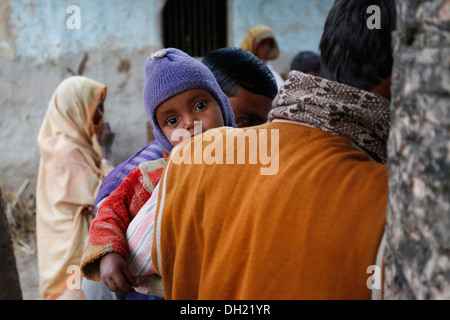 Un giovane bambino sul braccio di suo padre, gli abitanti di un villaggio vicino Rajbiraj, Terai regione, Nepal, Asia Foto Stock