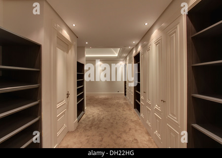 Cabina armadio con grande armadio a muro con porte in legno laccato bianco,  bagno con piastrelle in marmo e pavimenti in legno di pino Foto stock -  Alamy