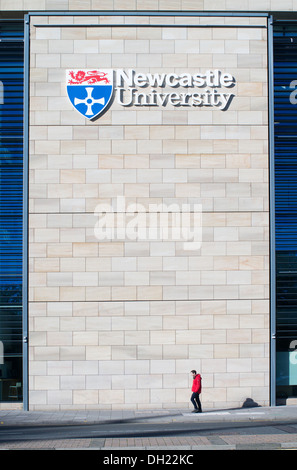 Un uomo cammina oltre la porta del re building, Università di Newcastle North East England, Regno Unito Foto Stock