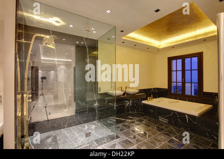 Lo schermo di vetro sulla doccia in piedi in spagnolo moderno bagno con accesi per incasso a soffitto Bagno di cui sopra Foto Stock