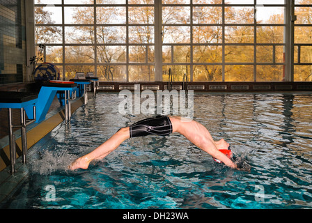 Il ragazzo, nuotatore, dodici o tredici anni, saltando, dorso, start, piscina Foto Stock