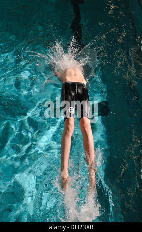 Il ragazzo, nuotatore, dodici o tredici anni durante il dorso inizio presso la piscina Foto Stock