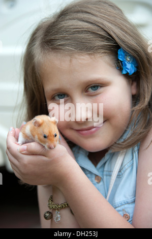 Giovane ragazza sorridente con pet di criceto modello completamente rilasciato Foto Stock