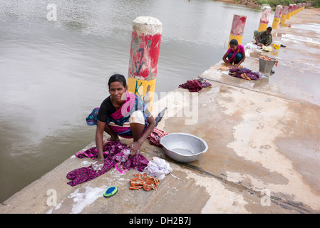 Le donne indiane il bucato a mano vicino a un fiume. Andhra Pradesh, India Foto Stock