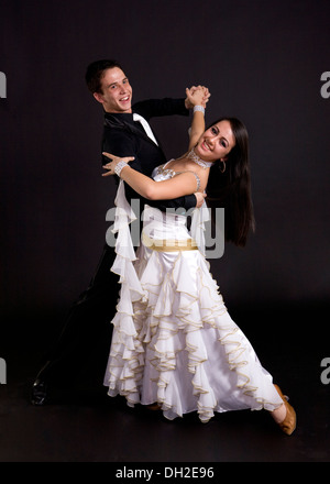 La sala da ballo giovani ballerini in costumi formale che pongono contro un solido background in studio Foto Stock