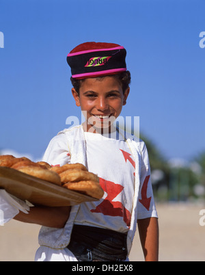 Giovane ragazzo vende pasticcini sulla Spiaggia di Sousse, Sousse, Sousse Governatorato, Tunisia Foto Stock