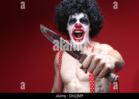 Il male Spooky Clown ritratto tenendo il coltello Foto Stock