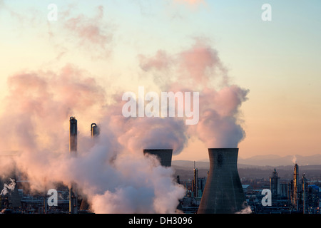 Grangemouth raffineria di petrolio di camini produca fumo in atmosfera, tramonto vapori di colorazione in rosa Foto Stock