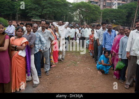 Gli elettori si accodano per votare al seggio elettorale Bombay Mumbai Maharashtra India Asia Foto Stock