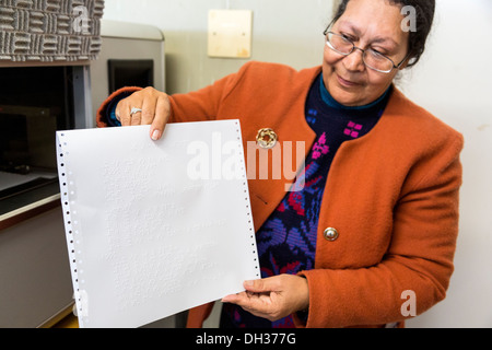 Sud Africa, Cape Town. Editor che mostra una pagina da una stampante Braille. Athlone scuola per ciechi. Foto Stock