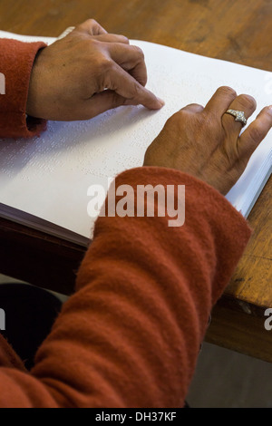 Sud Africa, Cape Town. Editor utilizzando la punta delle dita per leggere il Braille un eserciziario per studenti. Athlone scuola per ciechi. Foto Stock