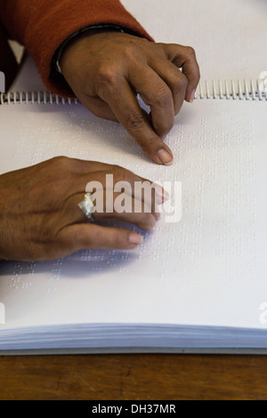 Sud Africa, Cape Town. Editor utilizzando la punta delle dita per leggere il Braille un eserciziario per studenti. Athlone scuola per ciechi. Foto Stock