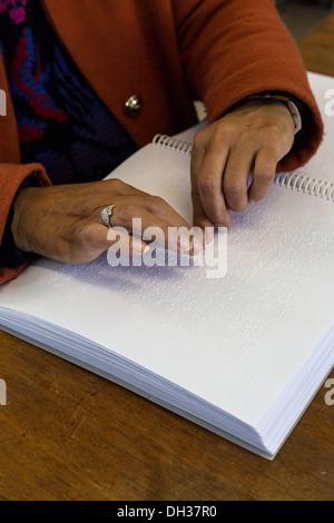 Sud Africa, Cape Town. Editor utilizzando la punta delle dita per leggere il Braille un eserciziario per studenti. Athlone scuola per ciechi. Foto Stock