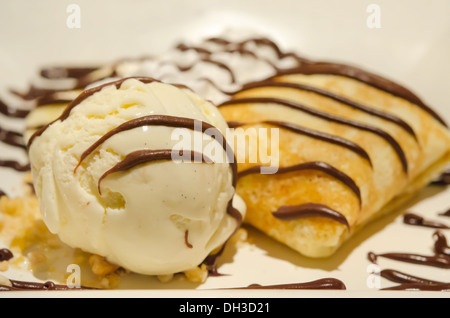 Crepes con banana , salsa al cioccolato servito con panna montata e gelato alla vaniglia Foto Stock