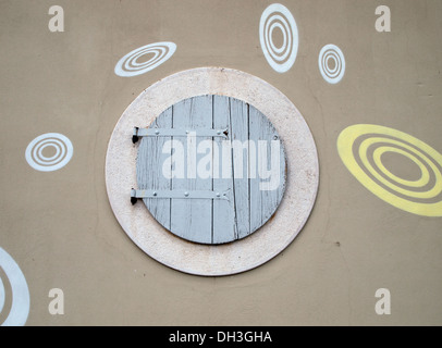 Round finestra in legno sulla facciata di edificio Foto Stock