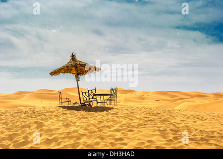 Ombrellone e sedie nel deserto Foto Stock