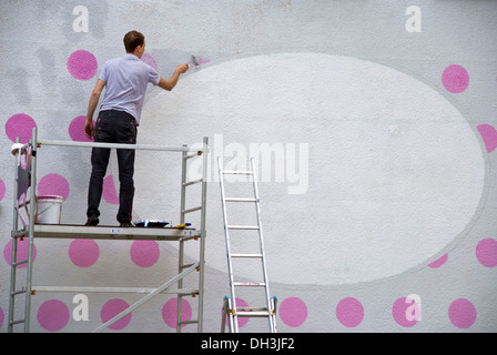 Giovane pittura facciata di una casa in Prenzlauer Berg di Berlino Foto Stock