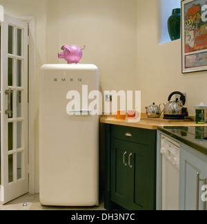 Rosa rosa in plastica su Smeg frigorifero in un angolo della cucina moderna con acciaio inox bollitore teiera sul piano di lavoro Foto Stock