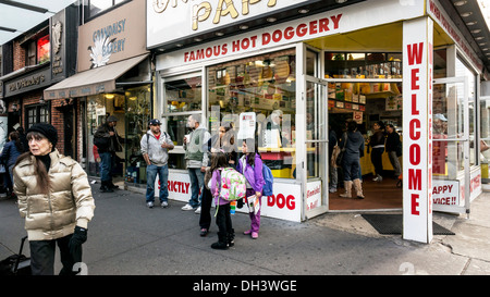 Madre con schoolgirl figlie al di fuori iconica del grigio papaia hot doggery Manhattan street scene angolo di 72& Broadway Foto Stock