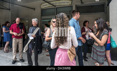 Diverse per lo più benestanti di fan del Daily Show con Jon Stewart in chat al di fuori sul marciapiede in attesa di essere ammesso Manhattan Foto Stock