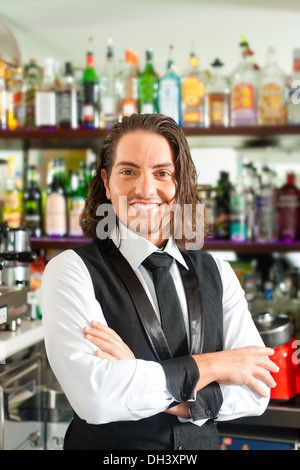 Giovane Barista o barman in piedi nella sua caffetteria o bar Foto Stock