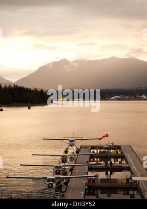 Al tramonto, quattro idrovolanti (piani di flottazione) ormeggiata al Porto di Vancouver Centro di Volo, Vancouver, Canada l'idrovolante terminale. Foto Stock