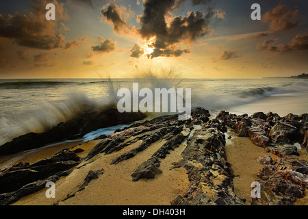 Le onde del mare linea gioco rock di impatto sulla spiaggia Foto Stock
