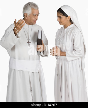 Sacerdote parlando di una monaca Foto Stock