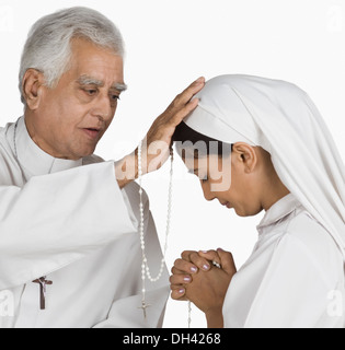 Nun confessare i propri peccati a un sacerdote Foto Stock