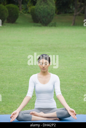 La donna a praticare yoga in un parco Foto Stock