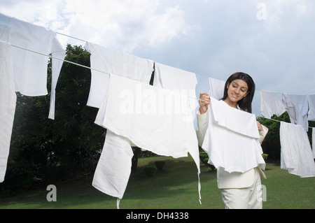 Imprenditrice appesi panni lavati prima di andare al lavoro Foto Stock