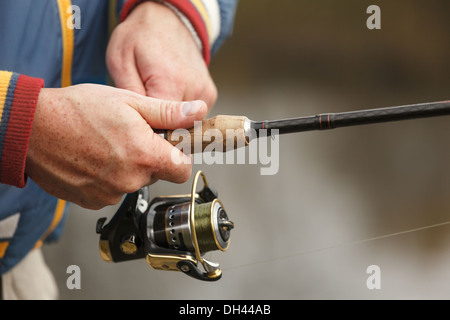 Vista dettagliata del pescatore la mano con la filatura - autunno stagione di pesca. Foto Stock