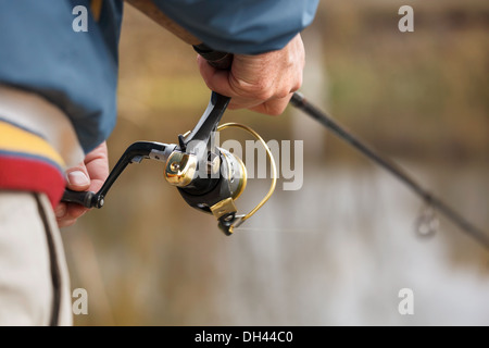 Vista dettagliata del pescatore la mano con la filatura - autunno stagione di pesca. Foto Stock