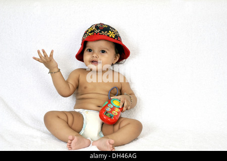 Il bambino che indossa il cappuccio e il pannolino seduto su sfondo bianco signor#736PA Foto Stock